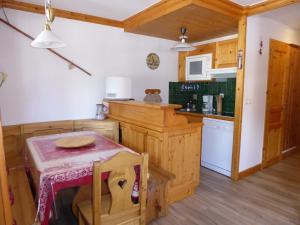 a kitchen with a small table and a counter at Appartement Confortable au Centre de Pralognan-la-Vanoise, Proche Téléphérique et Commerces - FR-1-464-107 in Pralognan-la-Vanoise +8 photos