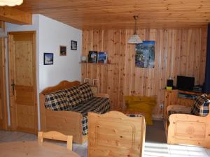 シャンパニー・アン・ヴァノワーズにあるAppartement Champagny-en-Vanoise, 3 pièces, 4 personnes - FR-1-464-128の木製の壁のリビングルーム(ソファ、椅子付)