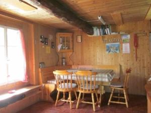 a dining room with a table and chairs and a tub at Rustico Bersacola in Bosco Gurin