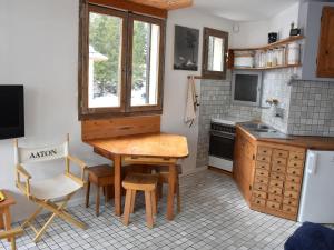 プラローニャン・ラ・ヴァノワーズにあるAppartement Pralognan-la-Vanoise, 2 pièces, 4 personnes - FR-1-464-132のキッチン(木製のテーブル、椅子付)