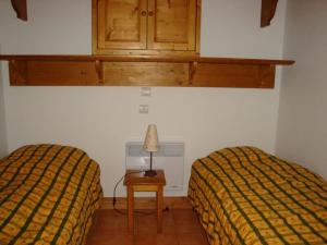 プラローニャン・ラ・ヴァノワーズにあるAppartement Pralognan-la-Vanoise, 3 pièces, 4 personnes - FR-1-464-111のベッドルーム1室(ベッド2台、ランプ付きテーブル付)