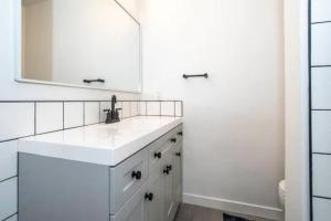 a white bathroom with a sink and a mirror at North End Bungalow in Boise