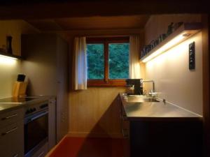 a small kitchen with a sink and a window at Studeweidli 6-Bettwohnung in Hasliberg