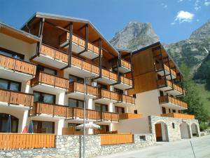 ein großes Gebäude mit Holzbalkonen und einem Berg in der Unterkunft Appartement Pralognan-la-Vanoise, 3 pièces, 6 personnes - FR-1-464-126 in Pralognan-la-Vanoise