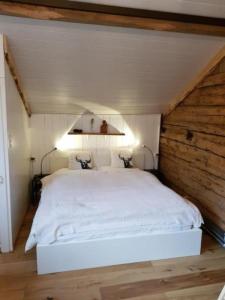 sypialnia z białym łóżkiem na poddaszu w obiekcie Studio Chic mit Whirlpool w mieście Wildhaus