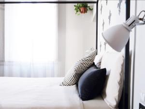 um quarto com uma cama com um candeeiro e almofadas em Domus 19 em Florença