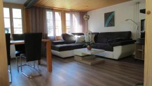 uma sala de estar com um sofá e uma mesa em Ursula und Daniel 6-Bettwohnung Meiringen em Meiringen