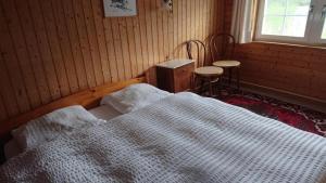 a bedroom with a white bed and a window at Ferien in der Vogelherd in Wolfhalden 