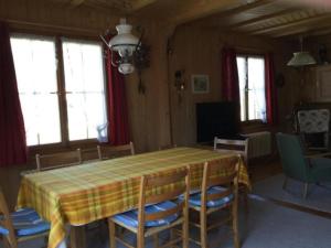 uma sala de jantar com mesa e cadeiras em Chalet mit grossem Umschwung em Cerniat