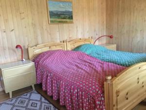 a bedroom with a wooden bed with a colorful bedspread at Chalet mit grossem Umschwung in Cerniat