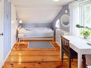 ein kleines Schlafzimmer mit einem Bett und einem Schreibtisch in der Unterkunft Holiday home GRISSLEHAMN VIII in Grisslehamn