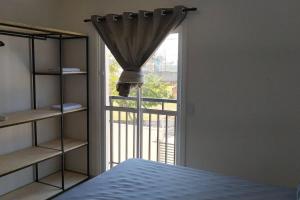 a bedroom with a bed and a window with a view at Refúgio, paraquedismo, balão, 130 km de São Paulo in Pôrto Feliz