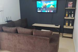 a living room with a couch and a flat screen tv at Refúgio, paraquedismo, balão, 130 km de São Paulo in Pôrto Feliz