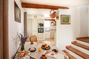 - une cuisine avec une table avec du pain et des oranges dans l'établissement Gîte St Roch en Luberon, à Castellet