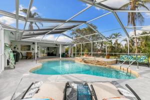 una piscina cubierta con techo de cristal en Spacious & Updated Lake Home- Great access to all 3 Downtown areas and Islands, en Fort Myers