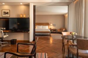 a living room with a bed and a dining room at Hotel Fasano Sao Paulo in Sao Paulo