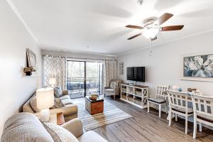 a living room with a couch and a ceiling fan at Beach Trees Lodge in Myrtle Beach