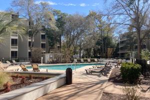 a swimming pool with chaises and chairs next to a building at Beach Trees Lodge in Myrtle Beach