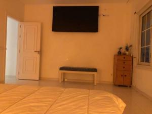 1 dormitorio con 1 cama y TV en la pared en Apartamento primera línea Puerto Banus con vistas, en Marbella