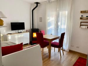 a living room with a table and chairs and a television at Appartamento Antey Saint André posizione centrale in Antey-Saint-André