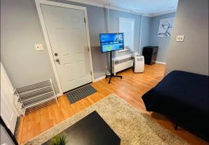 een kamer met een woonkamer met een televisie en een deur bij Cozy Apartments close to New York City in North Bergen