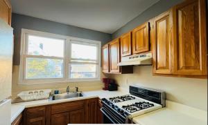 cocina con fogones, fregadero y ventana en Cozy Apartments close to New York City, en North Bergen