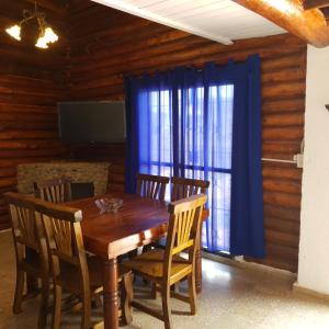 una sala da pranzo con tavolo e sedie in legno e una finestra di Cabaña Mimi a Ciudad Lujan de Cuyo