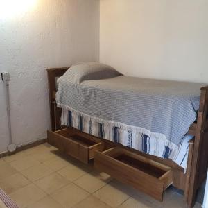 a bed in a room with a wooden bed frame at Cabaña Mimi in Ciudad Lujan de Cuyo