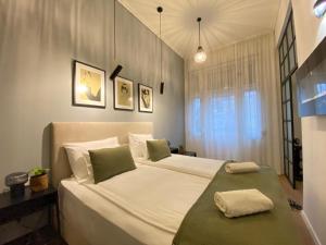 a bedroom with a large white bed with two pillows at Synagoge view loft bestern in Szeged