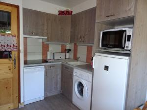 een keuken met een wasmachine en een magnetron bij Appartement Champagny-en-Vanoise, 3 pièces, 4 personnes - FR-1-464-1 in Champagny-en-Vanoise