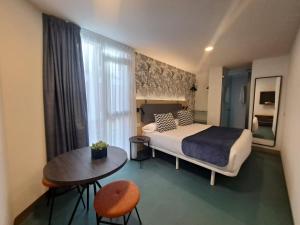 a bedroom with a bed and a table and a window at RK Farallón Canteras in Las Palmas de Gran Canaria