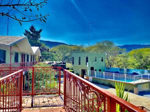 d'un balcon avec une balustrade rouge et une maison. dans l'établissement HOTEL RESTAURANTE TEQUILA, à Jalpan de Serra