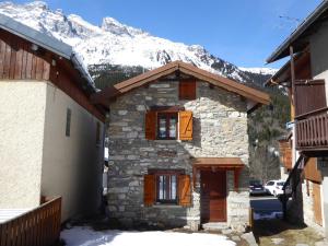 a stone building with a snow covered mountain in the background at Chalet Pralognan-la-Vanoise, 3 pièces, 6 personnes - FR-1-464-16 in Pralognan-la-Vanoise