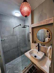 a bathroom with a sink and a shower and a mirror at Escape to 203 Umdloti Holiday Resort in Umdloti