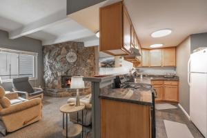 une cuisine avec des placards en bois et un salon dans l'établissement Lake View Condo: Walk To Downtown/Lake Dillon, à Dillon