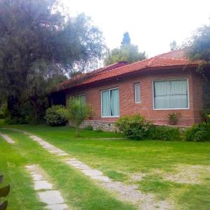 una casa de ladrillo rojo con un patio de hierba en Libertad Posada y Spa en Villa Las Rosas
