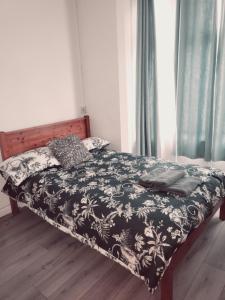 um quarto com uma cama com um edredão preto e branco em Entire Flat city centre based. em Parkside