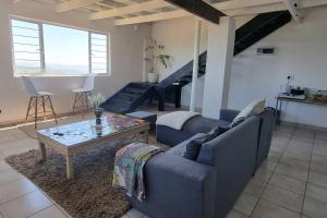 a living room with a couch and a coffee table at Best view of 1000 Hills with shared pool. in Bothaʼs Hill