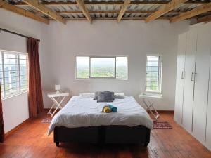 sypialnia z dużym łóżkiem w pokoju z oknami w obiekcie Best view of 1000 Hills with shared pool. w mieście Bothaʼs Hill