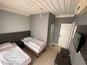 a bedroom with two beds and a tv in it at sıla pansiyon in Edirne