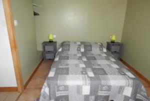 ein Schlafzimmer mit einem Bett und zwei Nachttischen mit zwei Lampen in der Unterkunft Le bon coin en Baie de Somme in Boismont