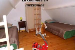 a cat standing in a room with a toy truck at Le bon coin en Baie de Somme in Boismont