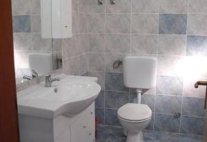La salle de bains est pourvue de toilettes blanches et d'un lavabo. dans l'établissement Hvar beach vacation, à Vrboska