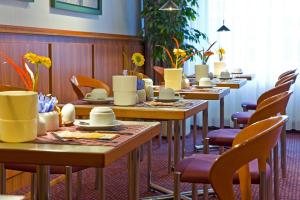 eine Reihe von Tischen und Stühlen in einem Restaurant in der Unterkunft Leine-Hotel in Göttingen