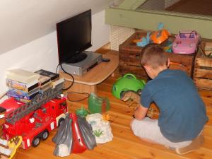 ein kleiner Junge sitzt auf dem Boden und spielt mit Spielzeug in der Unterkunft Le bon coin en Baie de Somme in Boismont