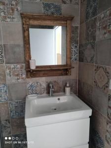 La salle de bains est pourvue d'un lavabo blanc et d'un miroir. dans l'établissement L'Affacatoghju - Grand studio au village (2p), à Tavera