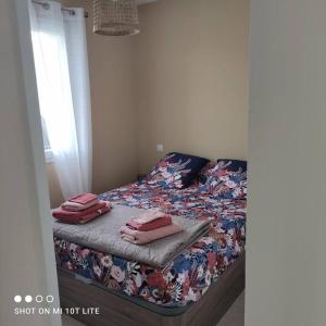 Un dormitorio con una cama con toallas rosas. en L'Affacatoghju - Grand studio au village (2p), en Tavera