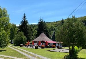 un cenador en un parque con árboles en Forrás camping, en Magyarhertelend