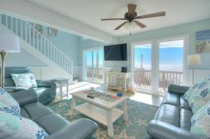 a living room with a couch and a table at Sea Change in Oak Island