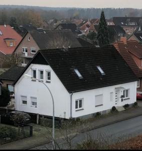 une maison blanche avec un toit noir dans l'établissement Ferienwohnung Soltau, à Soltau